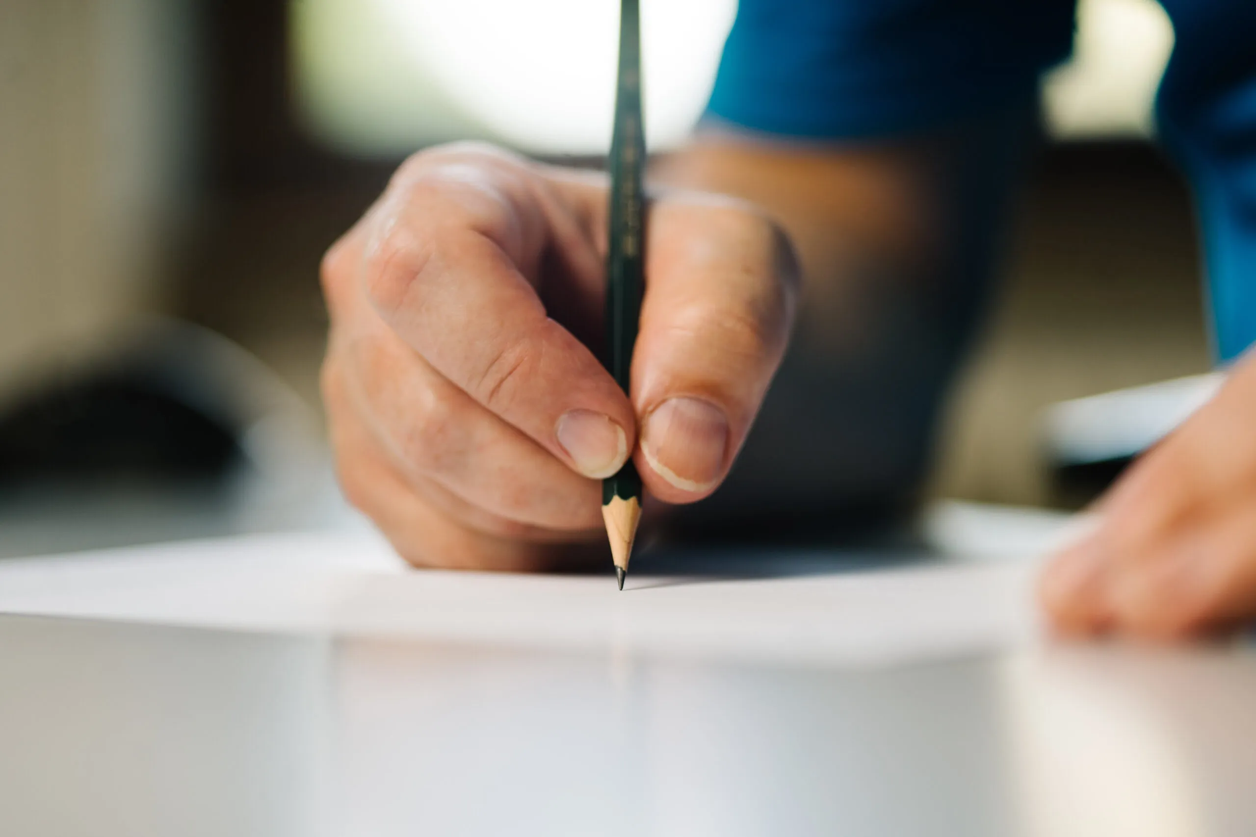 Eine Männerhand die etwas in eine technische Dokumentation schreibt